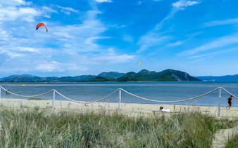 Kiteboarding on the beach at Delta Neretva, Croatia with mountains in the background.
