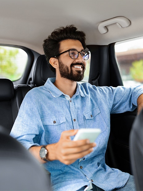 Passenger in transfer car holding phone, traveling in Istanbul.
