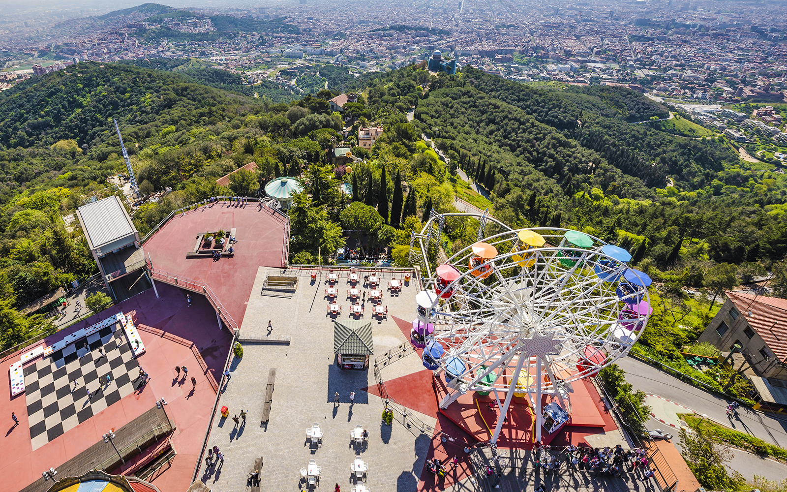 Aerial view of Tibidabo Amusement Park with Ferris wheel and cityscape in Barcelona.