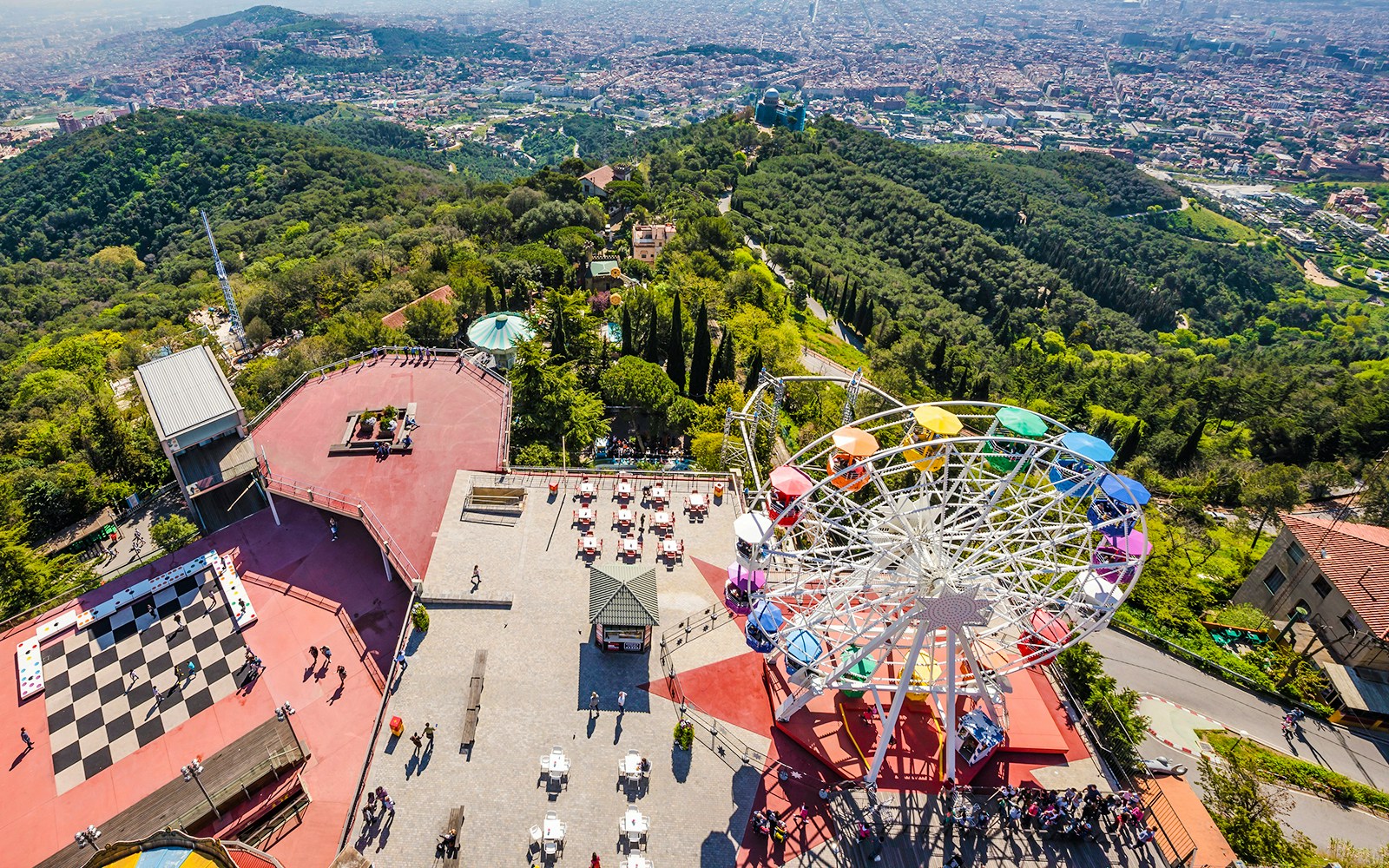 Aerial view of Tibidabo Amusement Park with Ferris wheel and cityscape in Barcelona.