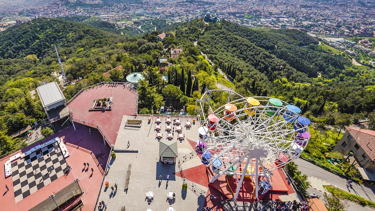 Aerial view of Tibidabo Amusement Park with Ferris wheel and cityscape in Barcelona.