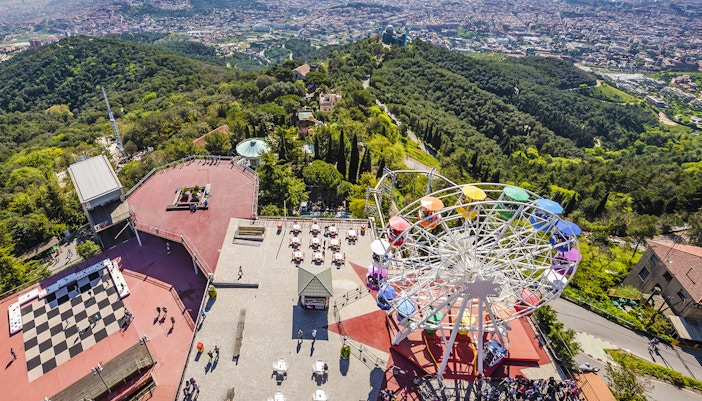 Aerial view of Tibidabo Amusement Park with Ferris wheel and cityscape in Barcelona.