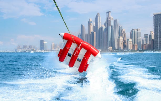 Fly Fish ride over water with Dubai skyline in the background.