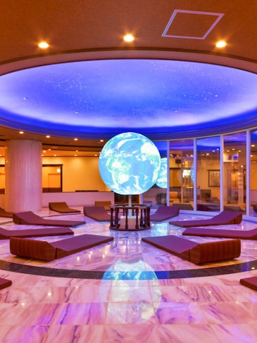 Spa World relaxation area with globe centerpiece and lounge chairs.
