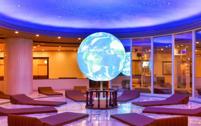Spa World relaxation area with globe centerpiece and lounge chairs.