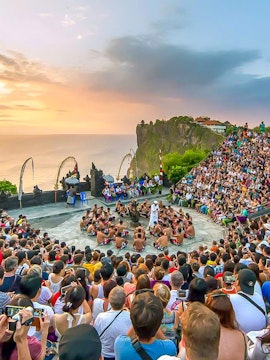 Crowd watching Kecak dance at Uluwatu Temple, Bali, during sunset.