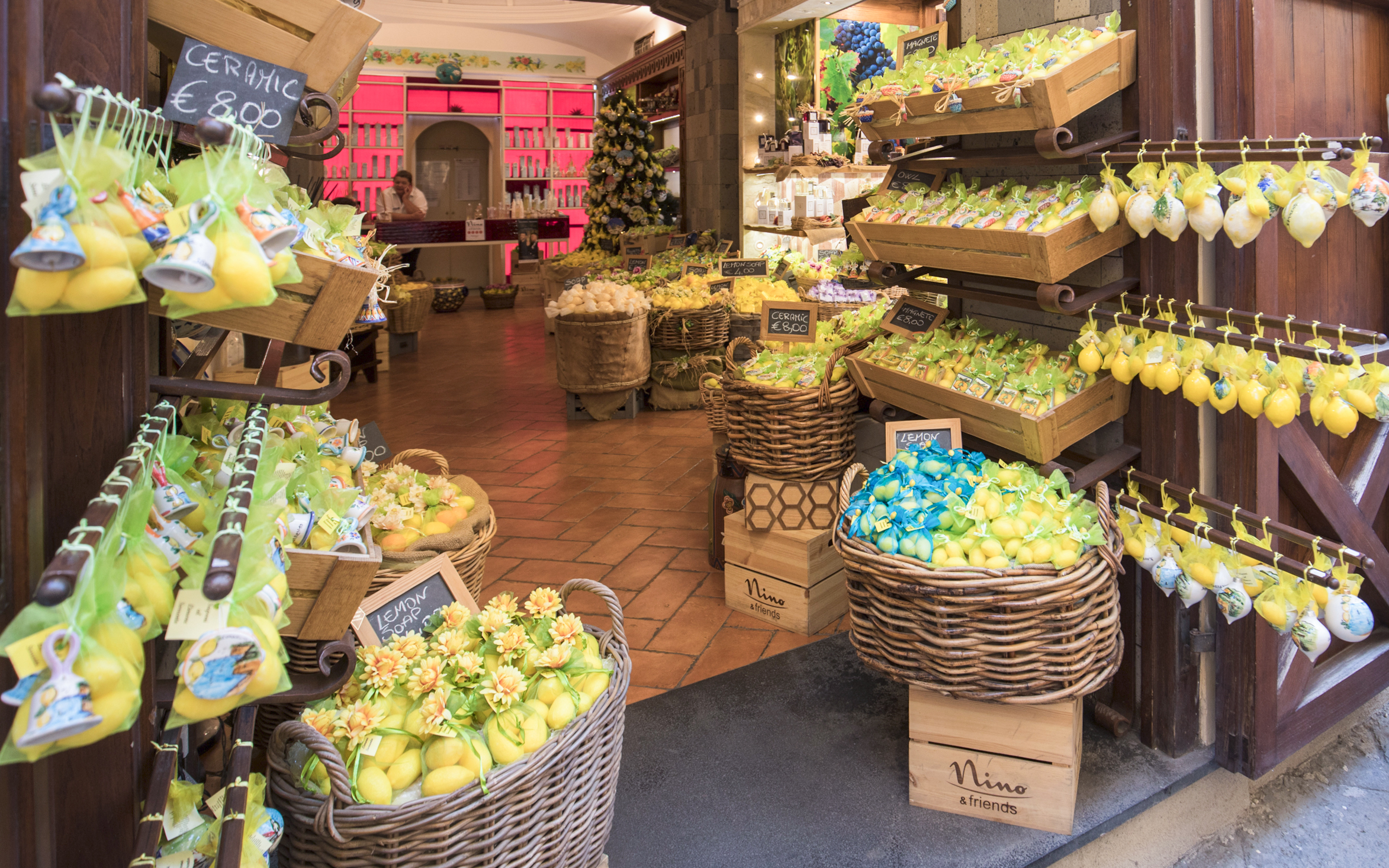 Souvenir shop in Sorrento, Italy with baskets of lemon-themed gifts and ceramics.