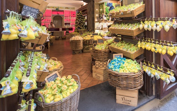 Souvenir shop in Sorrento, Italy with baskets of lemon-themed gifts and ceramics.