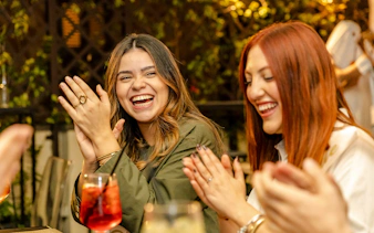 Guests enjoying the Tipsy Tour in Rome, clapping and smiling with drinks.