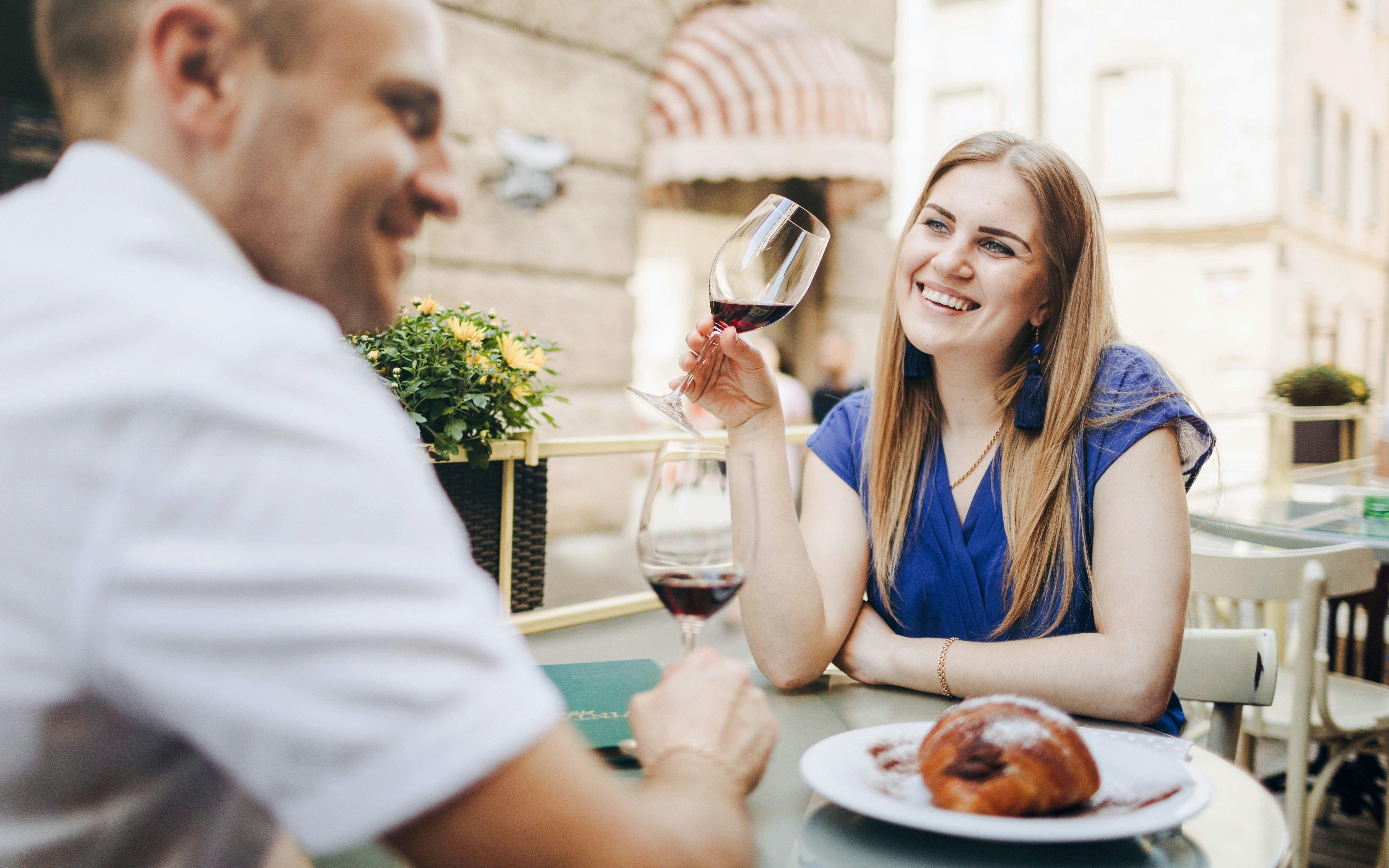 Couple enjoying wine and pastries at a Paris cafe.