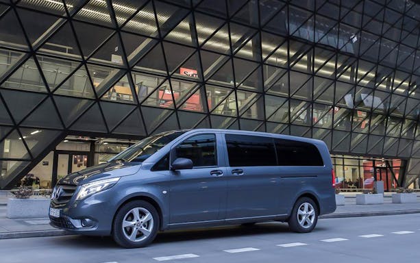 Minivan parked outside Krakow Balice airport terminal.