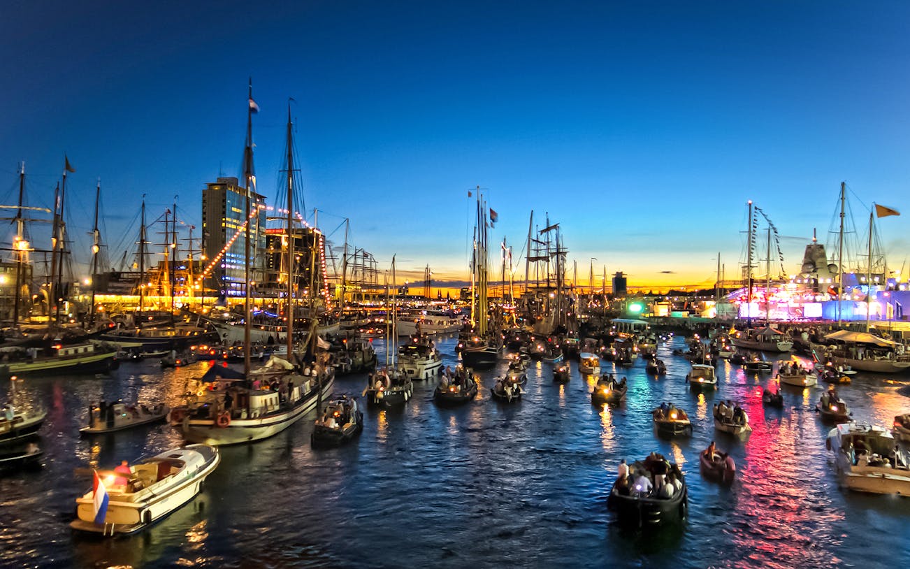 Sailboats illuminated at night during SAIL Amsterdam festival, Netherlands.