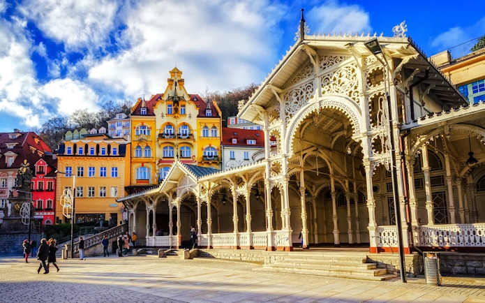 Historic colonnade and colorful buildings in Karlovy Vary street view.