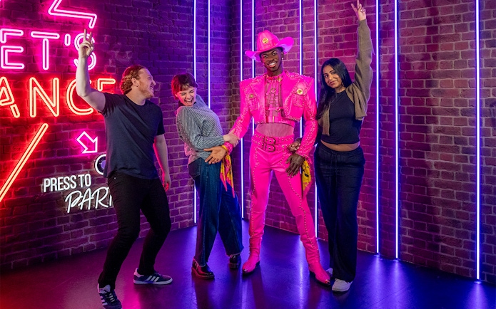 Visitors posing with Lil Nas X figure at Madame Tussauds London.