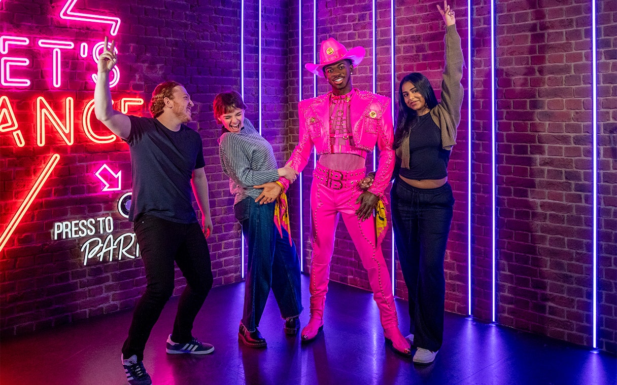 Visitors posing with Lil Nas X figure at Madame Tussauds London.