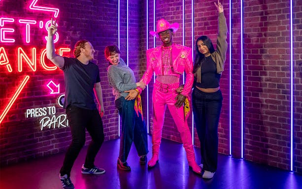 Visitors posing with Lil Nas X figure at Madame Tussauds London.
