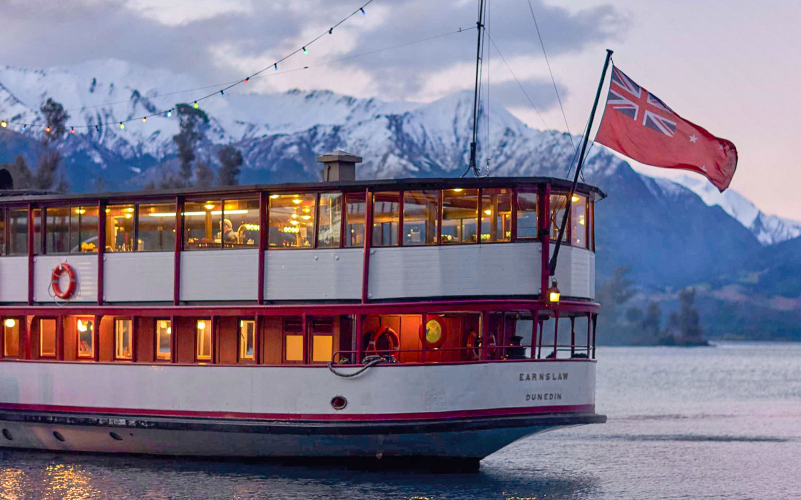 TSS Earnslaw steamship cruising on Lake Wakatipu with scenic Queenstown mountains in the background.