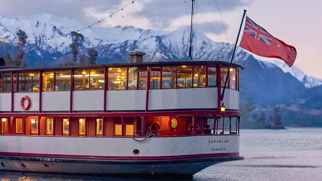 TSS Earnslaw steamship cruising on Lake Wakatipu with scenic Queenstown mountains in the background.