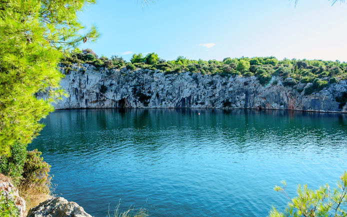 Dragon’s Eye lake with rocky cliffs and greenery in Rogoznica, Croatia.