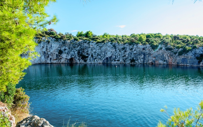 Dragon’s Eye lake with rocky cliffs and greenery in Rogoznica, Croatia.