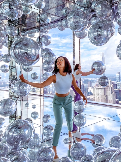 Visitors exploring mirrored room with reflective spheres at SUMMIT One Vanderbilt, New York City.
