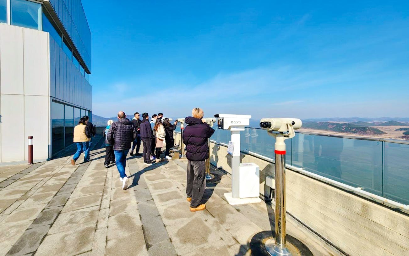 Visitors at Aegibong Observatory viewing DMZ landscape, South Korea.