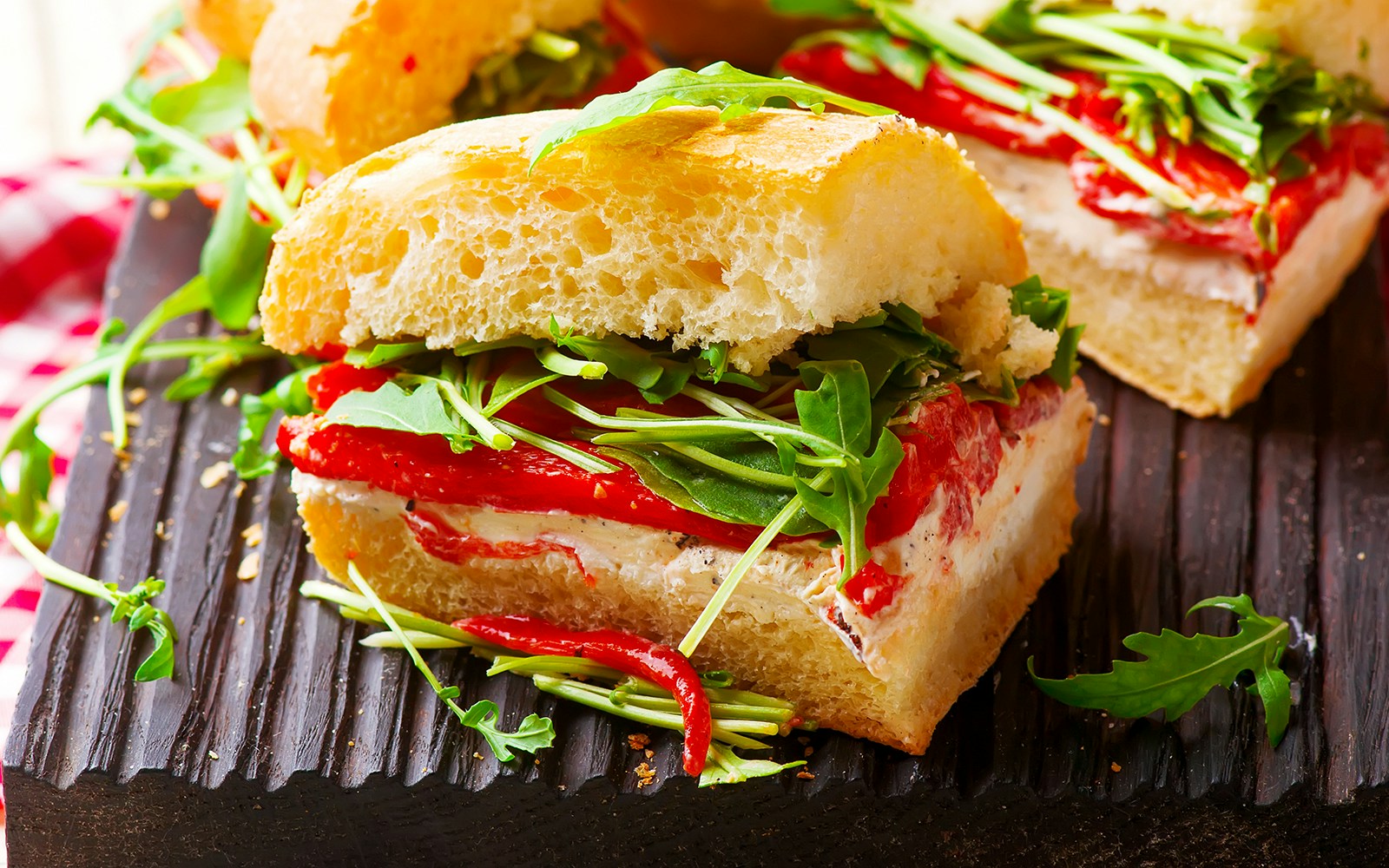 Focaccia sandwiches with roasted red pepper and arugula close-up.