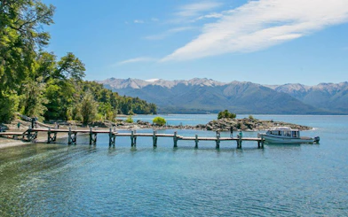 Pier extending into Lake Nahuel Huapi with distant mountain views.
