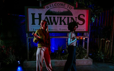 Guests exploring Hawkins sign at Stranger Things games, Netflix House, Philadelphia.