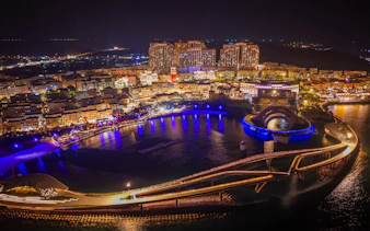 Aerial view of Kiss Bridge and Symphony Show lights in Phu Quoc at night.