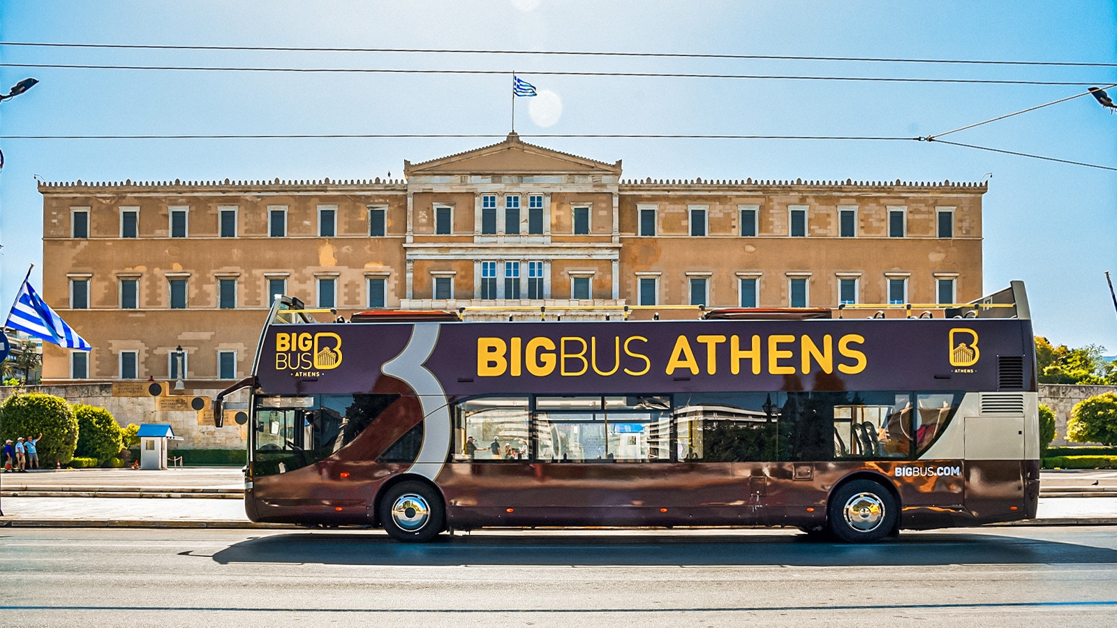 Athens Hop-on Hop-off bus tour showcasing a vibrant city view with historical landmarks and blue skies