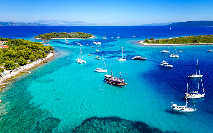 Boats anchored in the clear waters of Blue Lagoon, Croatia, near the underwater museum.