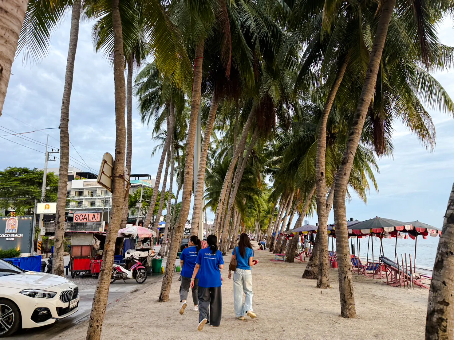 Beachfront path lined with palm trees in Bangsaen, part of the Bangkok to Bangsaen ATV & Sunset Adventure.