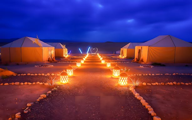 Night camp setup with lit lanterns in Agafay Desert, Marrakech.