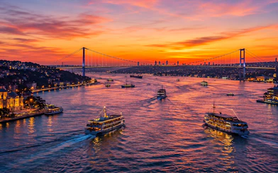 Boats on the Bosphorus at sunset with the Bosphorus Bridge in Istanbul.