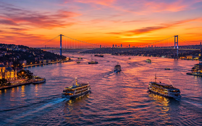Boats on the Bosphorus at sunset with the Bosphorus Bridge in Istanbul.