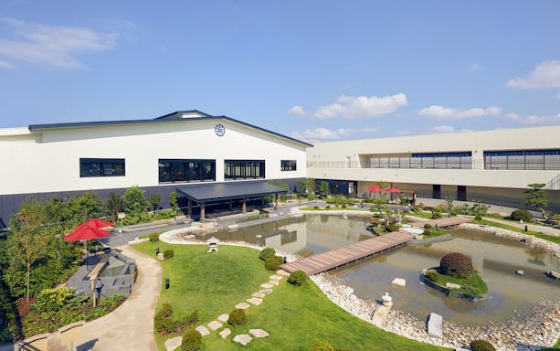 Exterior view of Solaniwa Onsen with garden and pond in Osaka, Japan.
