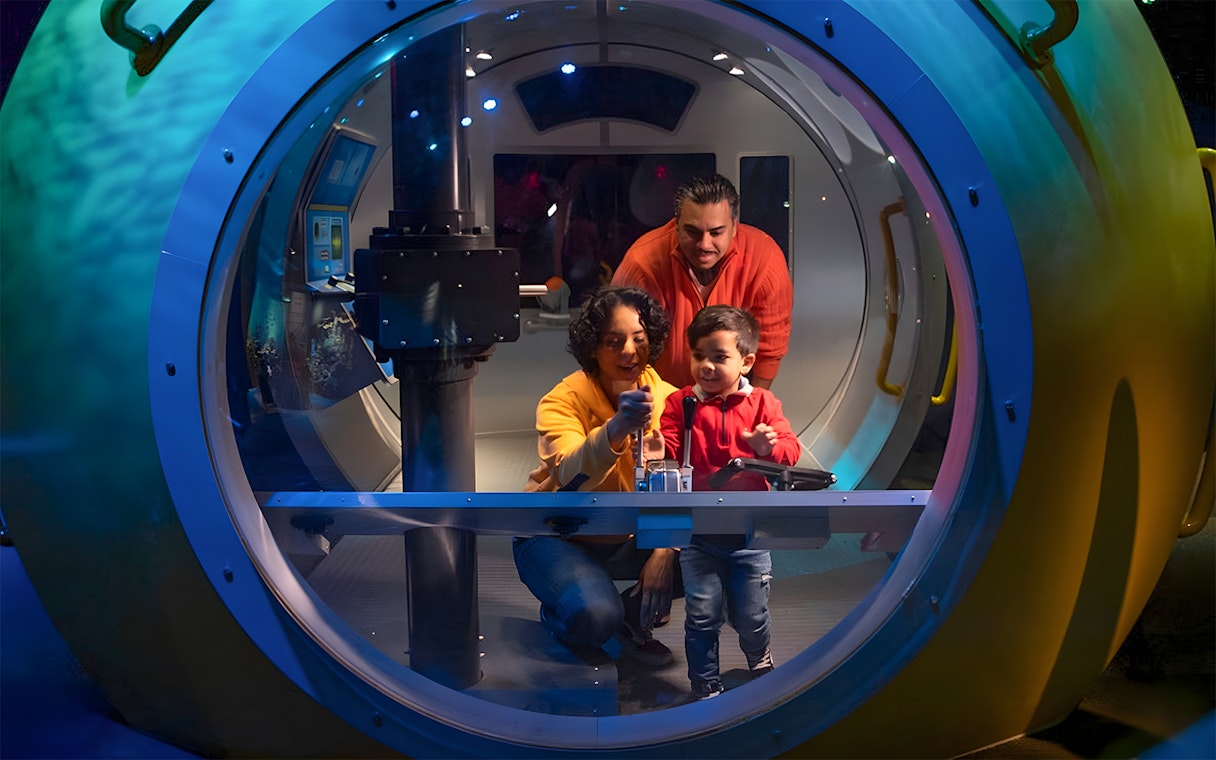 Family exploring interactive exhibit at New York Aquarium.