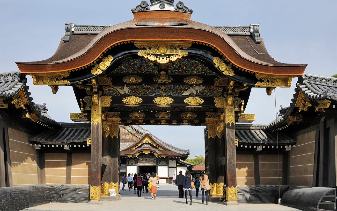Nijo Castle entrance in Kyoto with tourists exploring the heritage site.