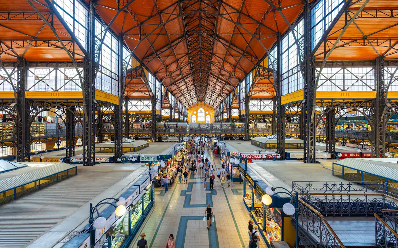 Central Market Hall in Budapest bustling with visitors exploring food stalls.