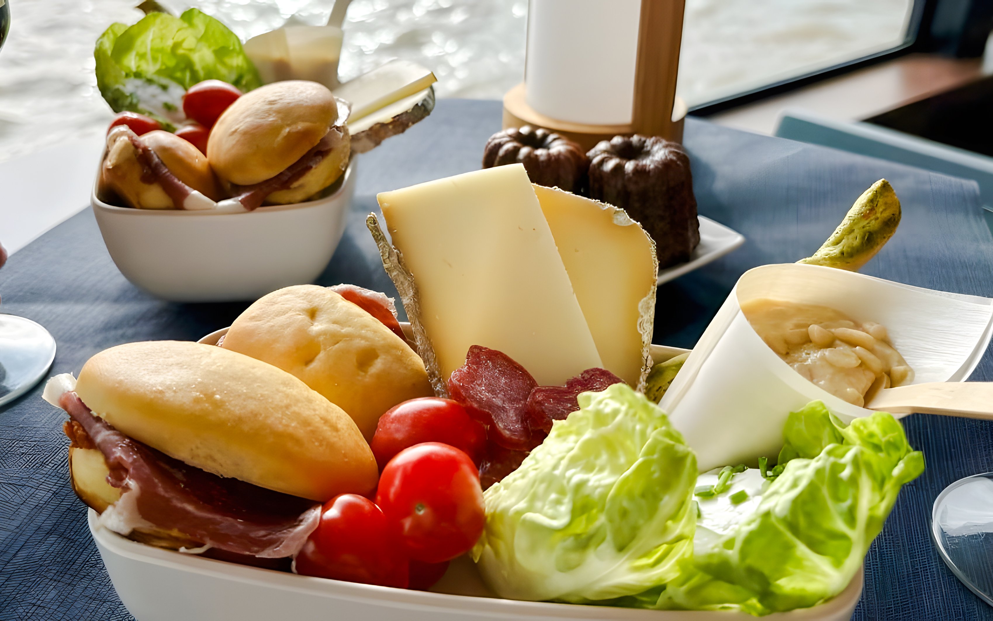 Cheese and charcuterie platter on Bateaux Bordelais Cruise with river view.