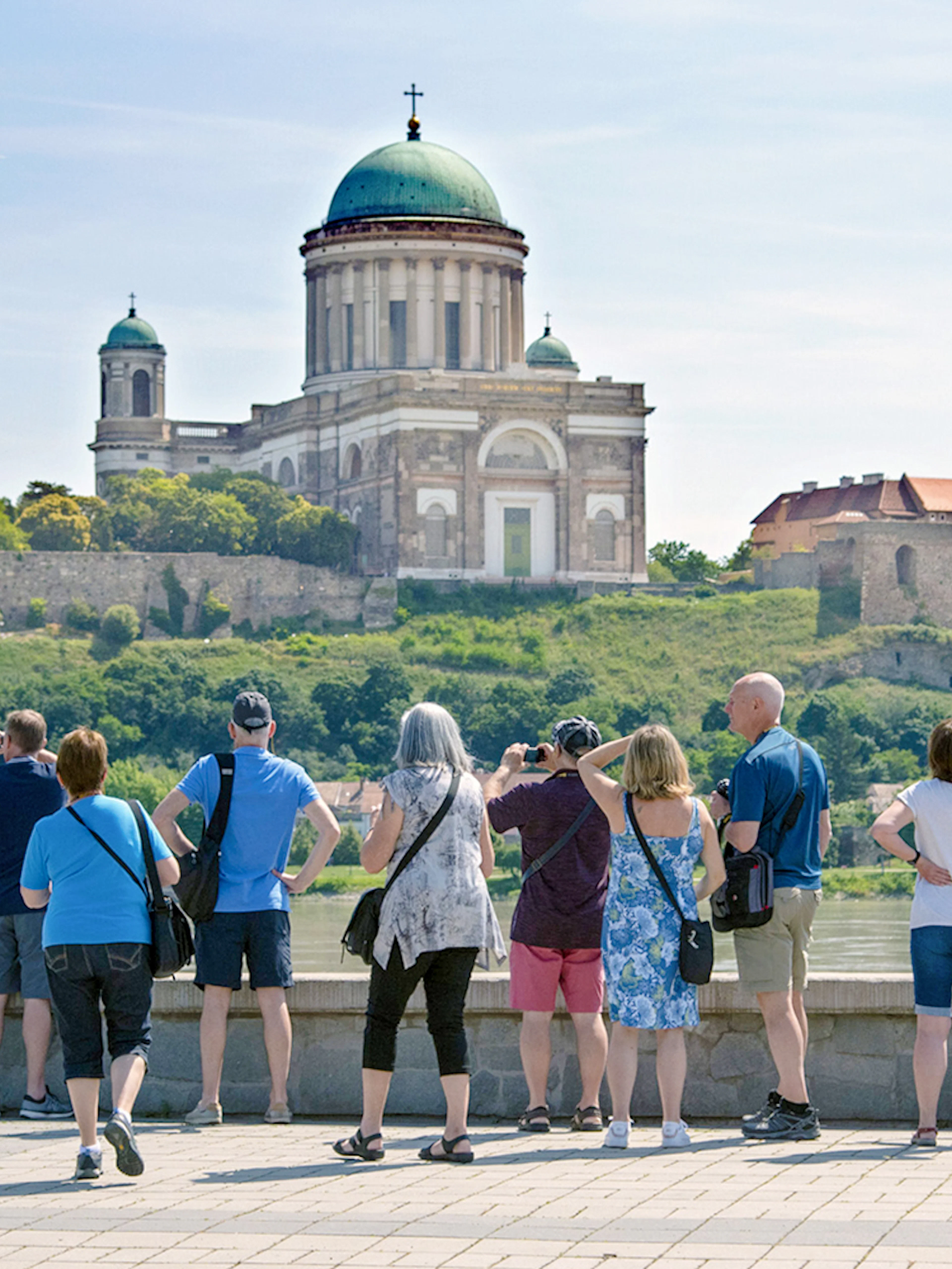 Tourists photographing Esztergom Basilica from across the Danube River in Hungary.