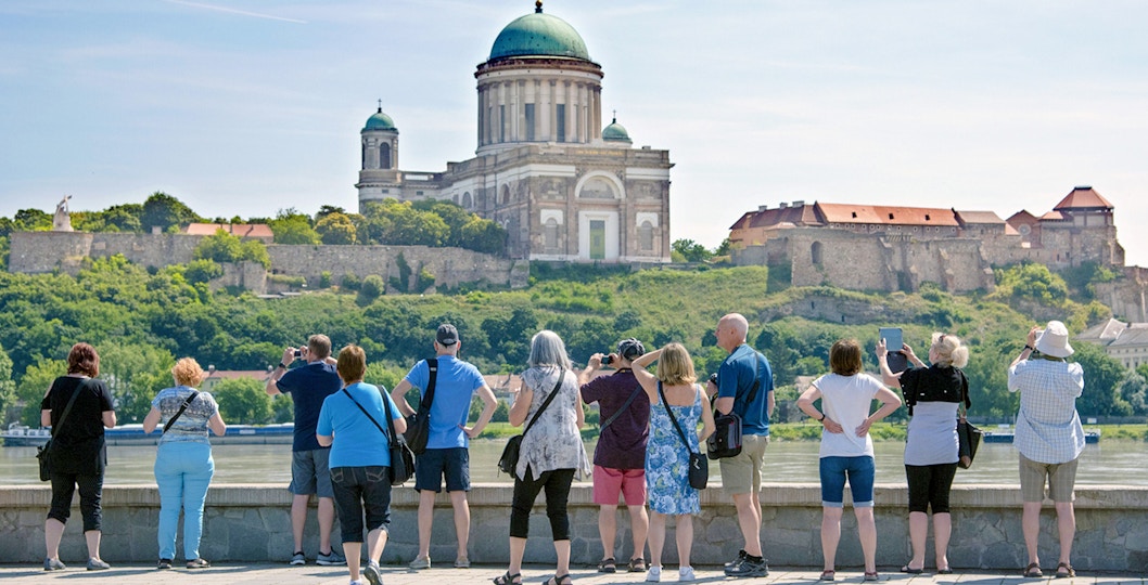 Tourists photographing Esztergom Basilica from across the Danube River in Hungary.