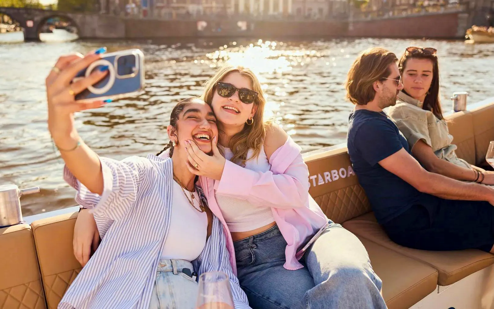 Friends enjoying a morning open boat cruise on Amsterdam's canals.
