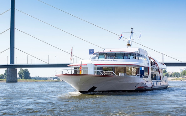Cruise ship on the Rhine River near a bridge in Düsseldorf.