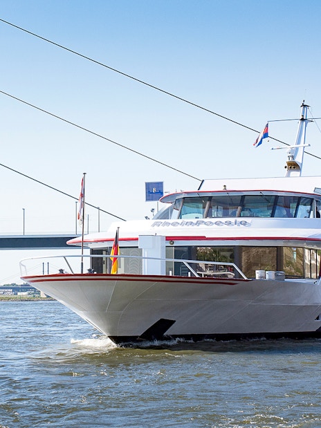 Cruise ship on the Rhine River near a bridge in Düsseldorf.