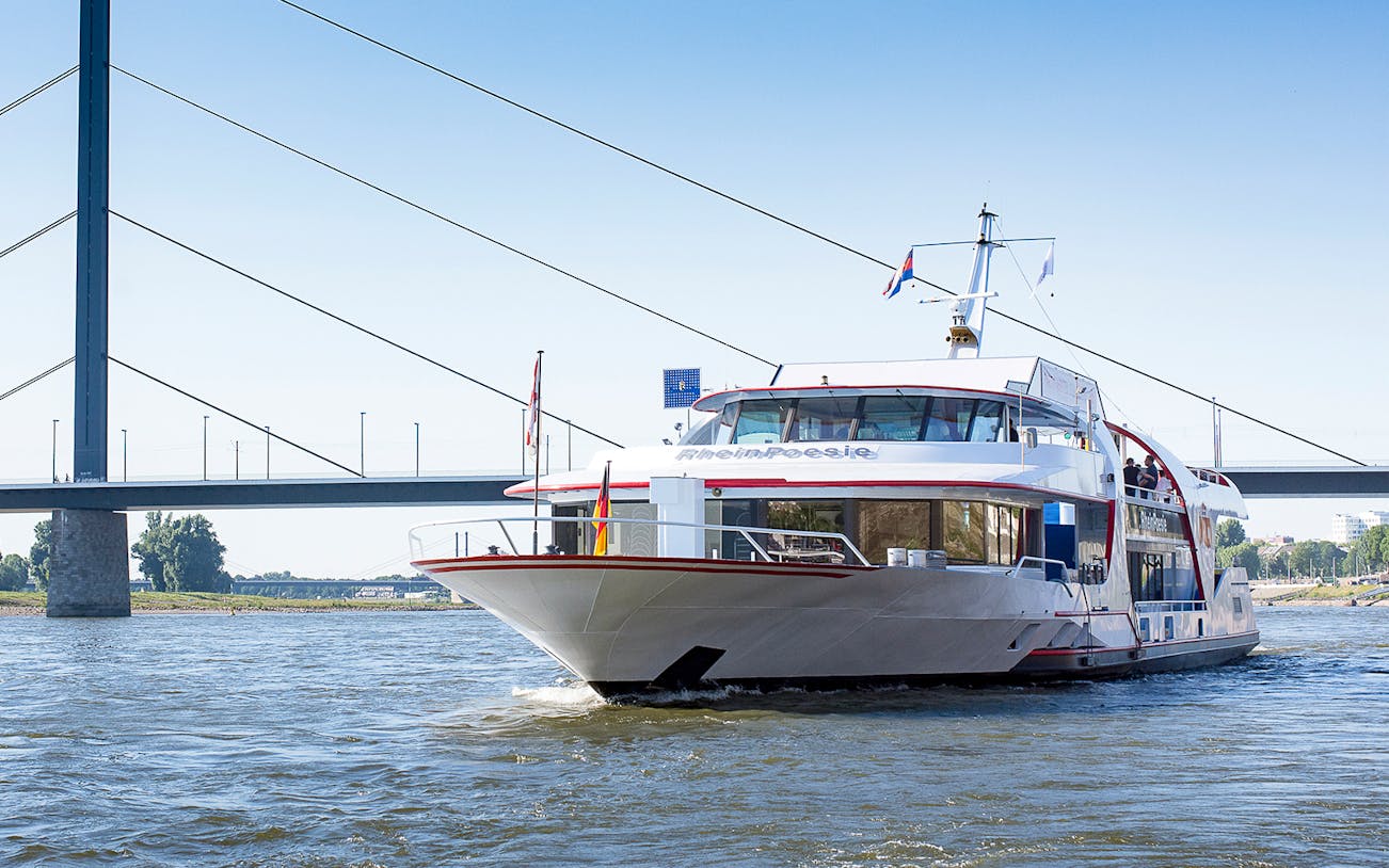 Cruise ship on the Rhine River near a bridge in Düsseldorf.