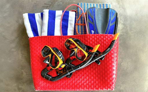 Scuba gear in a red basket with towels and fins for Similan Islands tour.