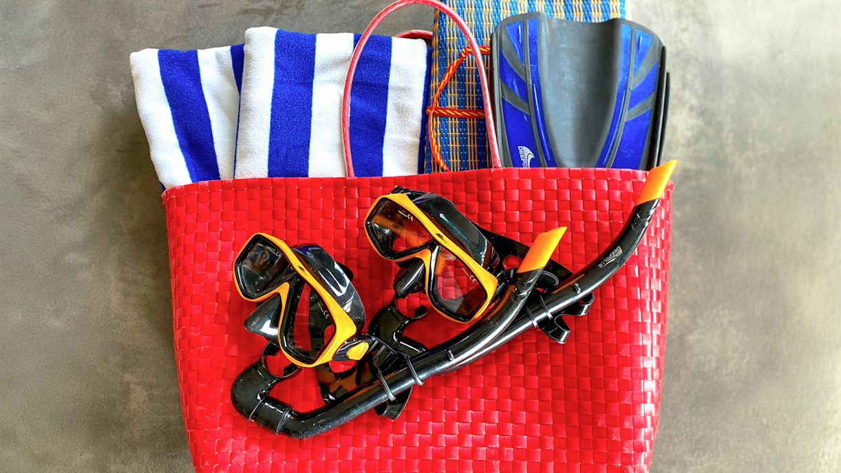 Scuba gear in a red basket with towels and fins for Similan Islands tour.