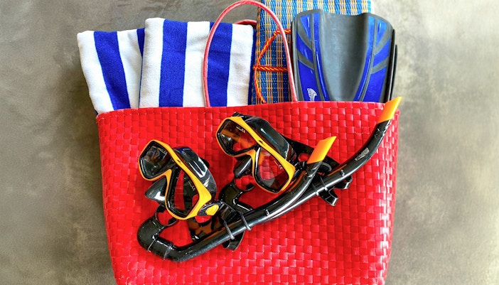 Scuba gear in a red basket with towels and fins for Similan Islands tour.